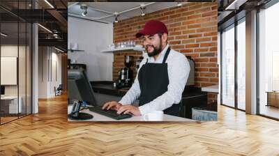 Hispanic barista man making coffee cup in a coffee shop in Latin America Wall mural