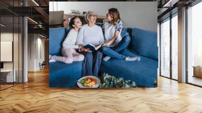 hispanic Family granddaughter and grandmother reading a book, woman senior at home in Latin America	
 Wall mural