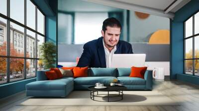 latin american man with beard working at computer at office in Mexico Wall mural