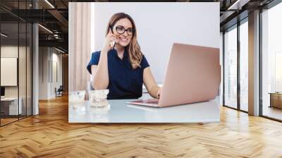 Latin dentist talking on the cellphone and using laptop Wall mural