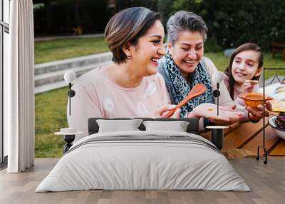 latin grandmother and granddaughter, daughter cooking mexican food at home, three generations of women in Mexico Wall mural