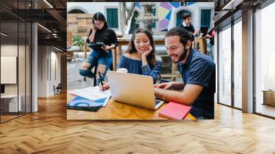 Smiling hispanic college students sitting while taking online class in Latin America Wall mural