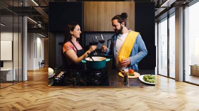 Young latin couple cooking dinner together in kitchen in home at night in Mexico Latin America, hispanic people Wall mural