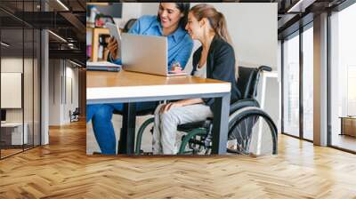 Young Mexican woman in wheelchair at office working with a latin girl in Mexico city Wall mural