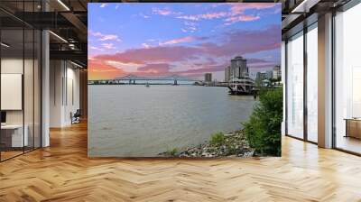 a gorgeous spring landscape along the MIssissippi River with boats sailing and the Crescent City Connection bridge with hotels and office buildings in the city skyline n New Orleans Louisiana USA Wall mural