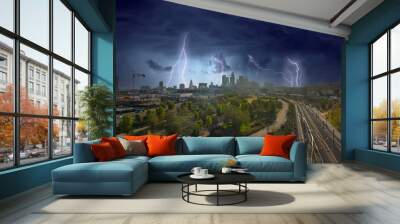 aerial shot of the skyscrapers and office buildings in the city skyline over Los Angeles State Historic Park with lush green trees with storm clouds and lightning in Los Angeles California Wall mural