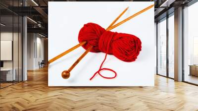 Pair of wooden knitting needles and red wool - white background Wall mural