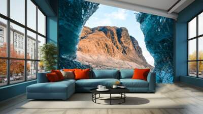 Solo female adventure traveler is discovering the ice caves in Iceland at Vatnajokull Glacier near to Jokulsarlon Glacier Lagoon. Tourism in abandoned Iceland . Outdoor living and exploring  Wall mural