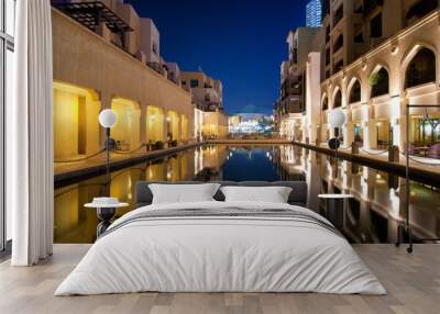 Colorful reflection of souk building in Downtown area during calm night. Calm water in hotel and restaurant pool. Dubai, United Arab Emirates. Wall mural