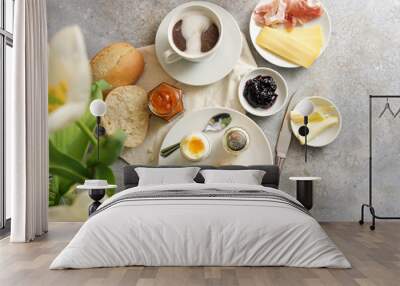 Continental breakfast with bread roll, cooked egg, jam, cheese, ham and coffee, light rustic background with copy space, high angle view from above, selected focus Wall mural