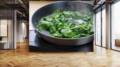 fried spinach leaves in a pan on the stove, healthy cooking concept Wall mural