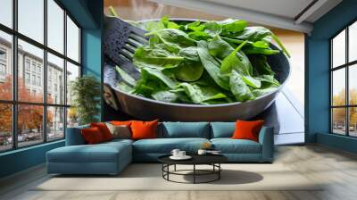 frying fresh spinach in a pan on the stove, healthy cooking at home concept Wall mural