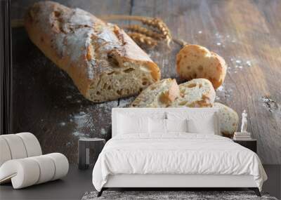 Half sliced baguette or French bread baked with onions on dark rustic wood Wall mural