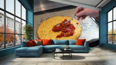 Hand is spreading tomato sauce on a pizza crust from shredded cauliflower, cooking a healthy alternative for slimming with low carb or ketogenic diet Wall mural