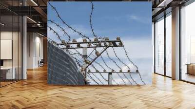 High Security Fence with electric barbed wire against a blue sky Wall mural