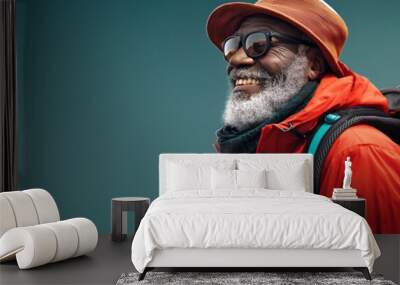 An elderly black man with a backpack smiling in outdoor hiking attire, concept of active lifestyle and adventure Wall mural