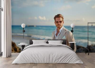 Handsome man in summer suit at the beach Wall mural