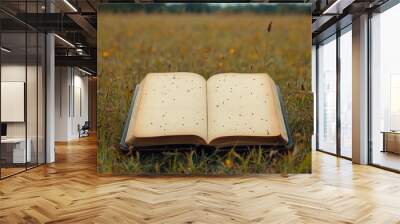 A diary, personal journal, or book is lying on the green grass in a field. An advertisement for a second-hand bookstore or a book blog. Desktop wallpapers. Wall mural