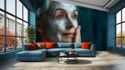 An old woman with a mask against wrinkles on her face. Skin care treatments for youthful skin. Advertising for a beauty salon. Old granny applying a rejuvenating sheet face mask, copy space. Wall mural