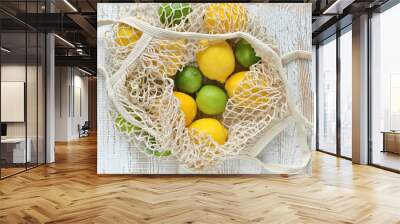 Bright yellow lemons & green limes in an Eco-friendly, low waste, reusable string bag tote Wall mural