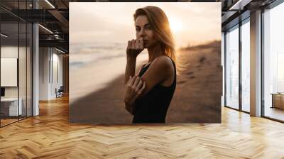 woman on beach is enjoying serene ocean nature during travel holidays vacation outdoors sunset time Wall mural