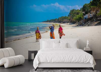 Three women walking on the beach in Jambiani, Zanzibar island, Tanzania Wall mural