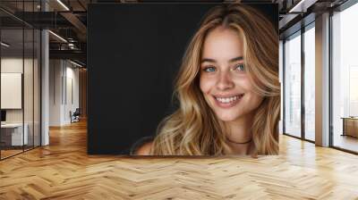 Happy pretty young woman with long blonde hair on a black background has a smiling face.copy space Wall mural