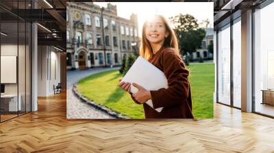 Happy student lifestyle, candid natural people life concept. Pretty beautiful girl teenager going to her class in university campus with laptop computer in hands, modern education technologies. Wall mural