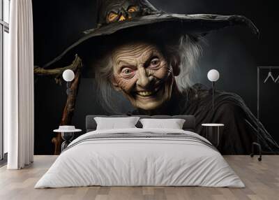 A good old smiling witch in a black dress and a magic hat on a dark background Wall mural