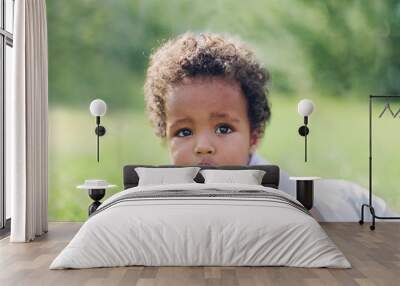 little african american boy lying in the park on the grass Wall mural