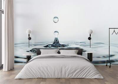 A drop of water falls on the surface of the water creating a splash, close-up Wall mural