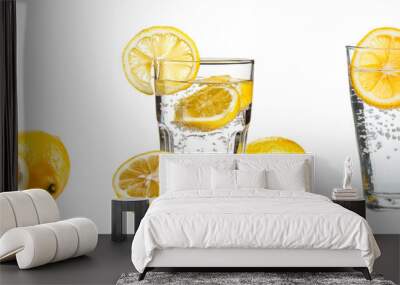 A glass of water with lemon. A transparent glass beaker with clean drinking water and lemon shamatok in it. Wall mural