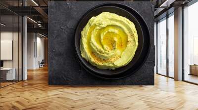 Bowl of green hummus, delicious cream of chickpeas and avocado on a stone  background. Wall mural