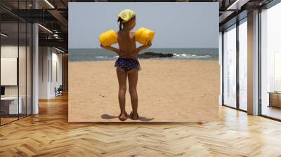 Beautiful little girl standing on the sandy beach. India, Goa Wall mural