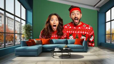 Christmas portrait of surprised couple wearing red ugly knitted sweaters. Wall mural