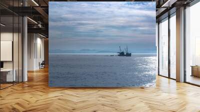 Fishing boat alone in sunrise lights Wall mural