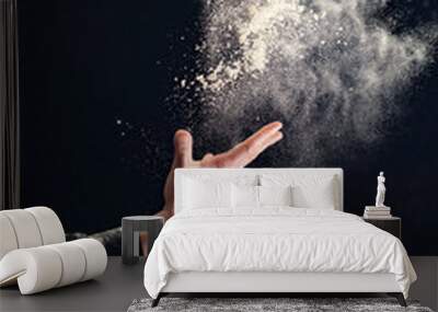 Man hands throw white powder on dark background Wall mural