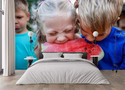 Healthy summer food. Group of kids eating watermelon together in the backyard of farmhouse Wall mural