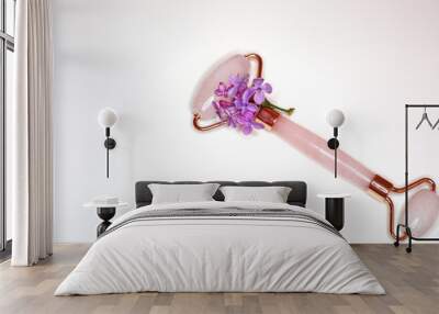 Pink quartz face roller massager for skin treatment on whit background. Home spa settings. Derma rollerю Wall mural