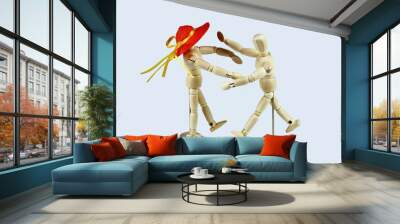 Pair of wooden mannequins, she with orange straw hat, running towards each other. Light background. Wall mural