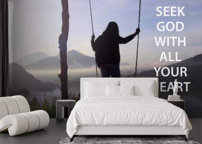 Bible verse quote - Seek God with all your heart. Jeremiah 29:13 With woman standing on natural wooden swing with misty morning view in the mountain. Christianity concept. Wall mural