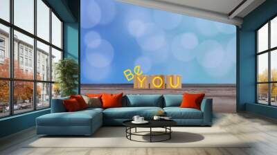 Inspirational quote - Be you. The real you with  creative words design on wooden cubes on soft vintage blue bokeh background. Be yourself  and self confident motivation text concept. Wall mural