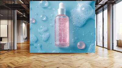 Refreshing pink serum bottle surrounded by water droplets and bubbles on a cool turquoise background, embodying hydration and skincare luxury. Wall mural