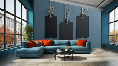 Three elegant black price tags hanging on twine against a teal background, creating a minimalist and stylish composition for retail or sale concepts.Friday and kiber monday concept Wall mural