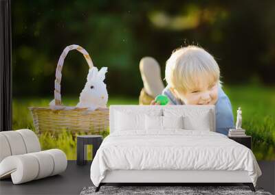 charming little boy hunting for easter egg in spring park on easter day Wall mural