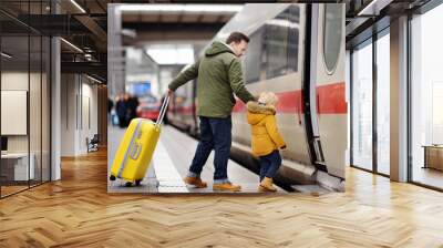 Little boy and his father go in express train on railway station platform Wall mural