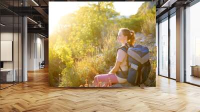 Young woman hiking in countryside. Backpacking hike Wall mural