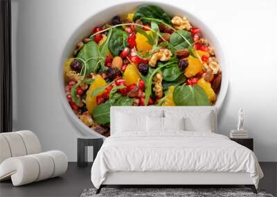 Isolated healthy salad with spelt, oranges, pomegranate seeds, nuts and greens, top view Wall mural