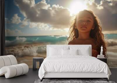 A little girl standing on a beach next to the ocean Wall mural