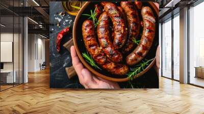 A person holding a bowl filled with sausages Wall mural